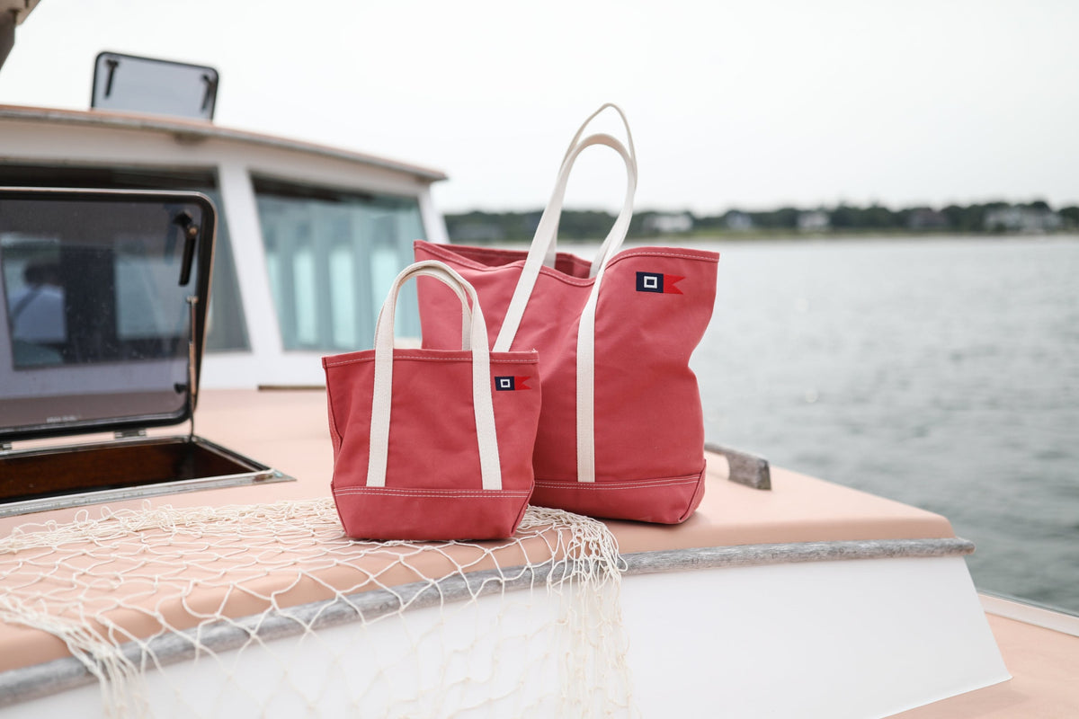 Signal Mini and Medium Totes on the cabin roof of the red lobster boat, with a draped net and open water