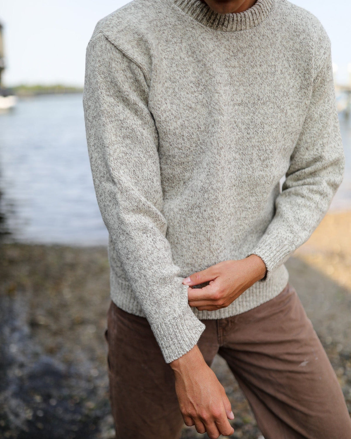 Whalerknits Wellfleet Classic Crewneck Jersey - Wool Blend: Front view of the light sweater worn with brown trousers while the wearer adjusts a sleeve.