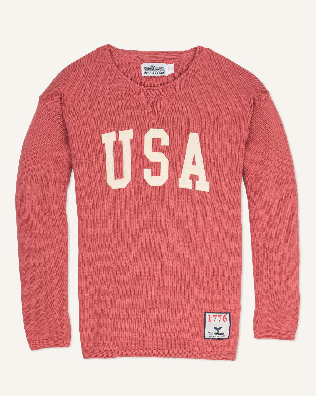 Whalerknits USA HOMETOWN Sweater: Nantucket Red sweater laid flat with large natural-colored USA lettering and a small hem patch. #Color_Nantucket Red