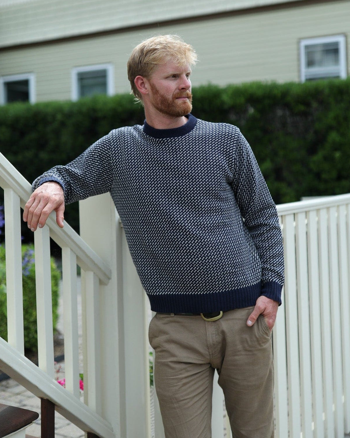 Whalerknits Sakonnet Birdseye Crewneck Pullover: A man in navy with natural birdseye pattern and tan trousers leans on a white railing.