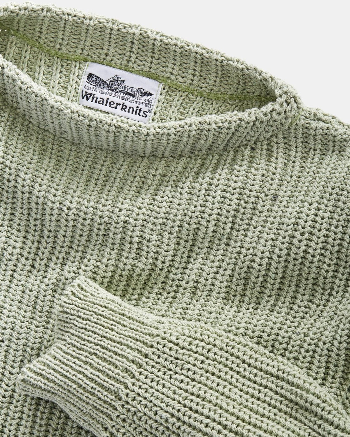 Whalerknits Newport Shaker Boatneck Sweater: Close-up of the light green boat neckline, ribbed cuff, knit texture and label.