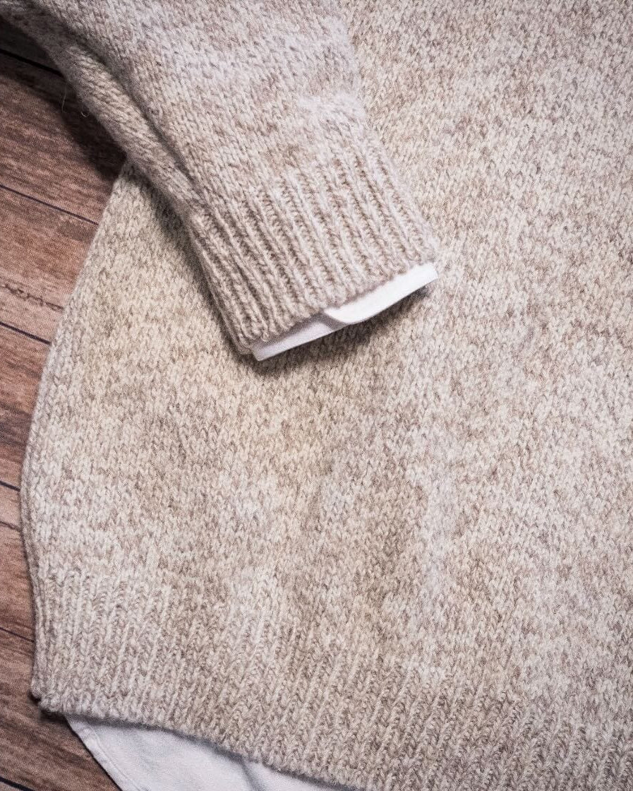 Whalerknits Wellfleet Classic Crewneck Jersey - Wool Blend: Close-up of a folded heathered sleeve, ribbed cuff and knit texture on a wooden surface.